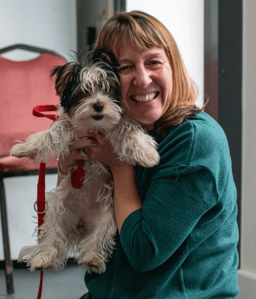Claire smiling and holding puppy